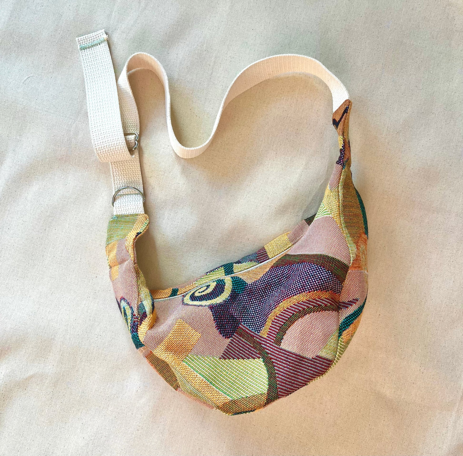 Cross body bag in an abstract fabric on a canvas background