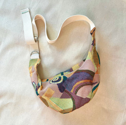 Cross body bag in an abstract fabric on a canvas background